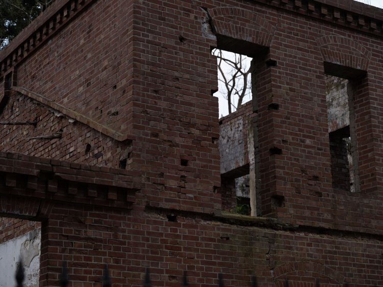 二階部分と平屋の屋根接合部。横一文字に凹んでいるのはバルコニーの板が食い込んでいたと思われる。屋根は朽ちたがレンガでその形状がなぞられており、どのような角度の屋根であったか想像できる。