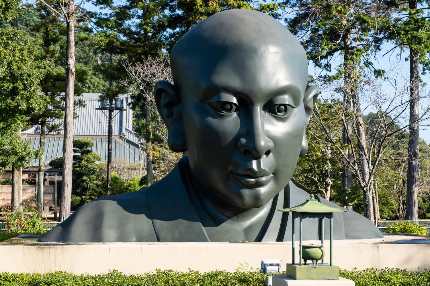 駐車場の一角に安置された日蓮大聖人大銅像頭部。現在、全体像建立資金を広く募っている。