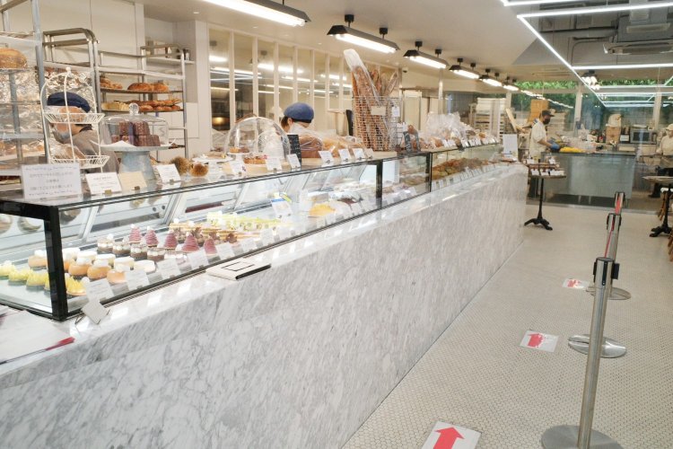 明るい店内の大きな大理石のカウンターにはパンとケーキ類がそろう。丁寧で程よくフレンドリーな接客も心地いい。店の奥にある厨房からは職人が手を動かす様子もよく分かる。