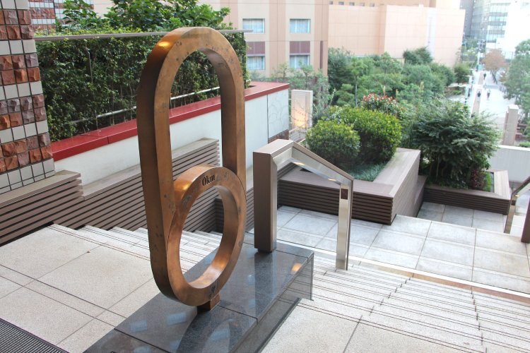 地中に埋め込まれたレールの先に「甲武鉄道始点の地」のモニュメントが。