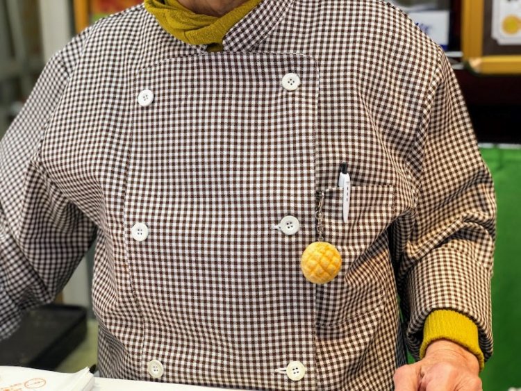 胸元を飾るメロンパンのキーホルダー。