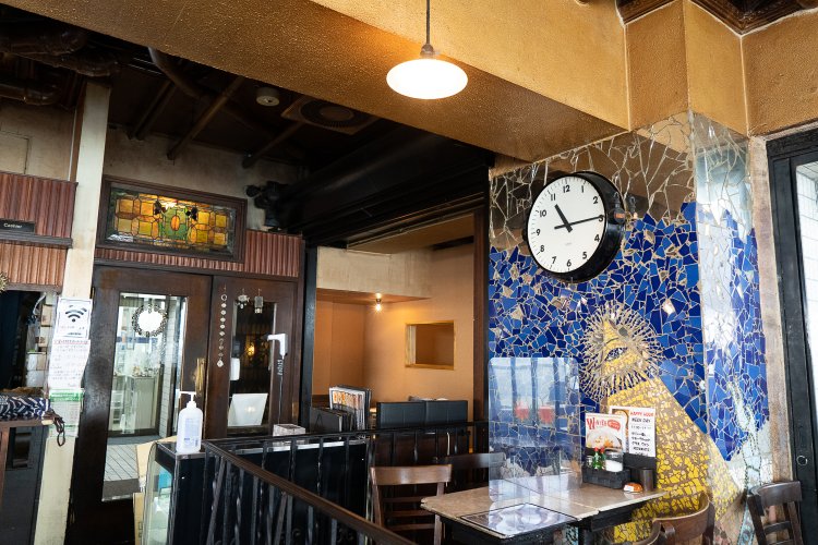 大きな時計はロンドンの駅で使われていたもの。柱のモザイクも店を印象付けている。