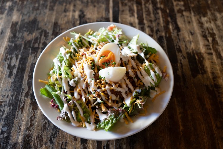 名物メニューのひとつ自家製チリミートのタコライス 半熟卵添えは1200円。