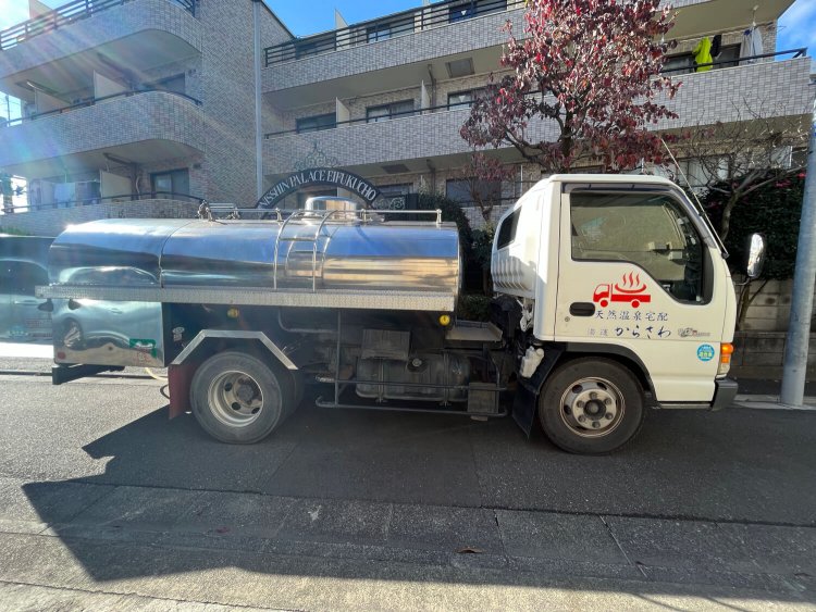 マンションに横付けされた温泉宅配専用のタンク車。