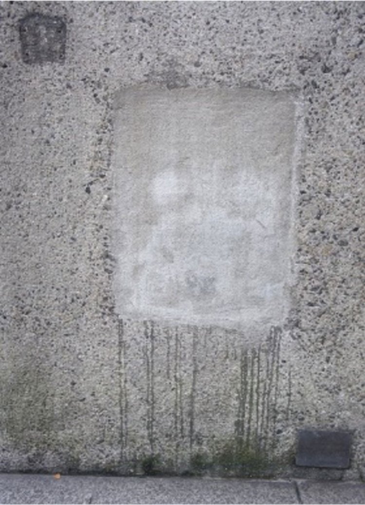 送水口の痕跡「送水痕」。壁にうっすら浮かぶ2つ目から涙を流しているようにも見える。