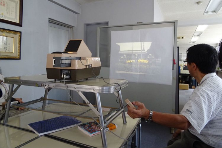 ご自身が撮影した送水口の写真を上映中の村上社長。