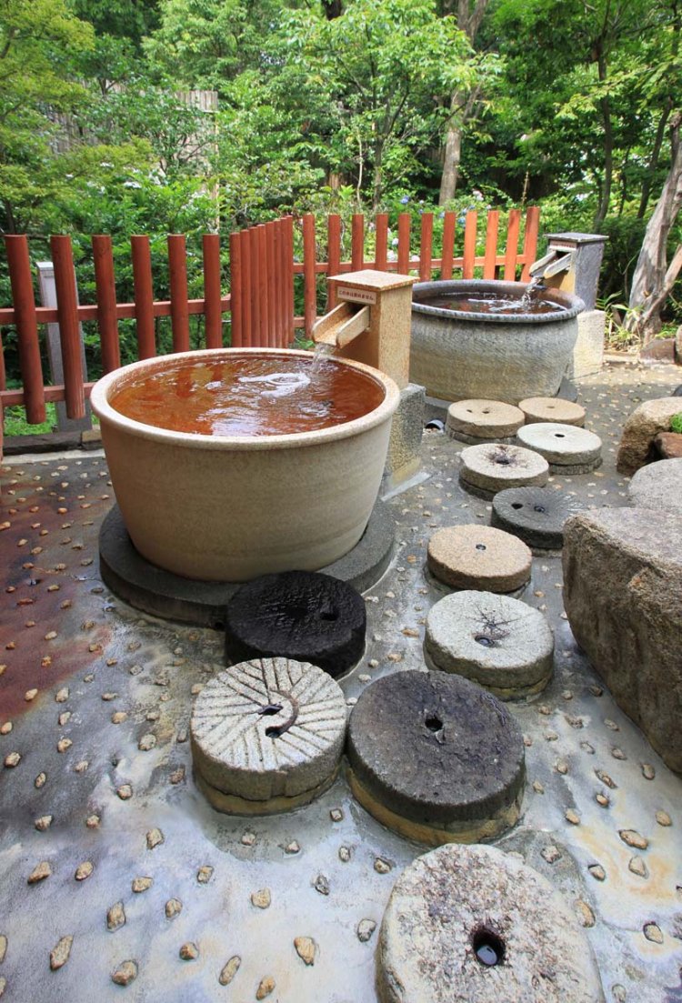 陶器の肌触りも優しい露天信楽焼風呂。浴槽に身を沈めれば、もったいないほどに温泉があふれ出す。