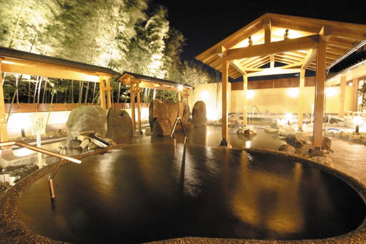 露天風呂の塀の向こうにライトアップされた竹林が浮かぶ。