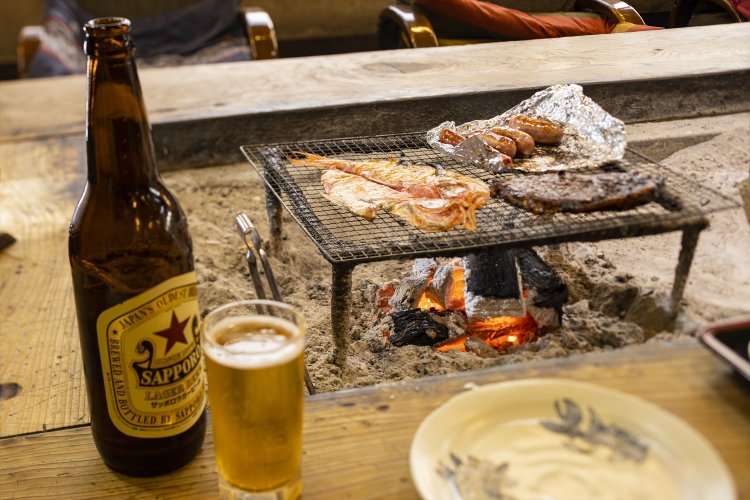 近所で焼いた火持ちのいい炭を使う囲炉裏。金目鯛の干物大、房総豚みそ焼各880円。瓶ビール赤星700円（酒は持ち込み不可）。