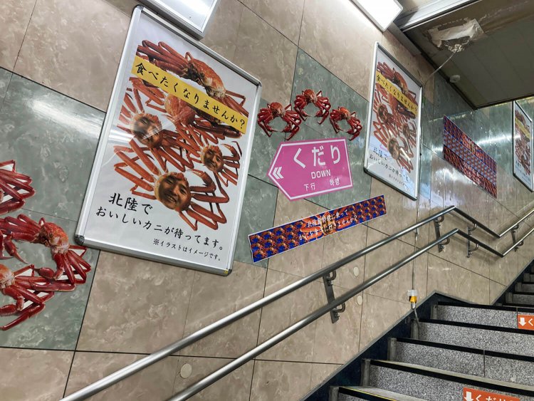 高円寺駅の階段では、このように人面ガニポスターと複数カニが交互に貼られている。