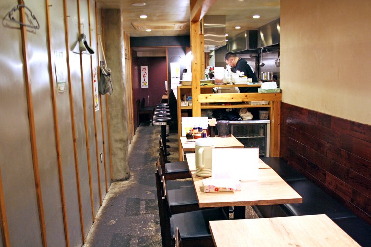 手前にテーブル席、カウンターを挟んで奥にもテーブル席がある。