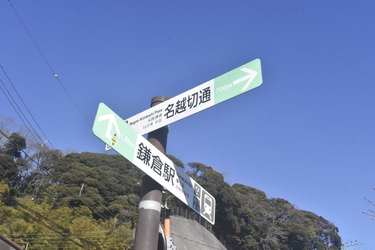 踏切を渡ると名越切通しへの案内標識が建っている。