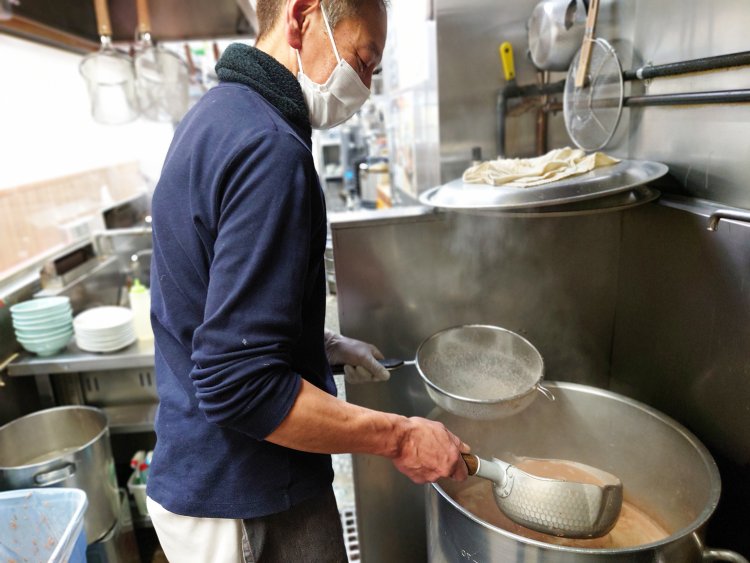 隣の寸胴に手作業で濾（こ）していき、ここから一杯ずつ丼へ注ぐ。