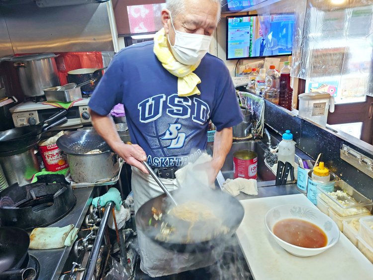 用意しておいた刻みネギ入りラーメンスープに炒めたソース焼きそばを投入する。