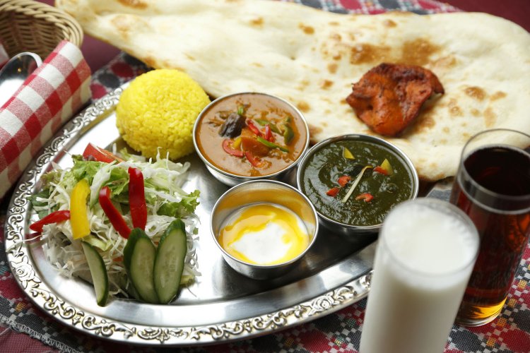 日替わりセット1050円。日替わりセットはランチのみ。カレー 2種、チキンディッカ、サラダ、ライタ、おかわり可のナンとライスがつく。