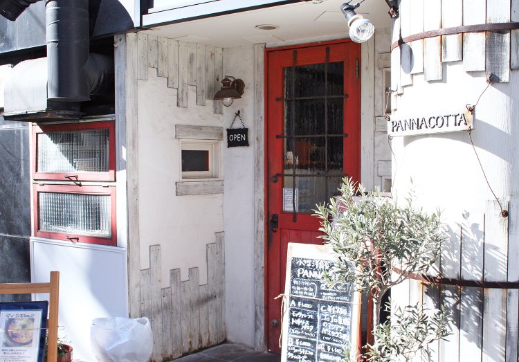 大通りから少し入った丁字路の角。赤いドアが目印。