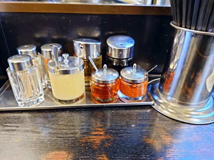 卓上には胡椒、一味唐辛子、醤油、酢、ラー油、豆板醤、おろしニンニクなど。