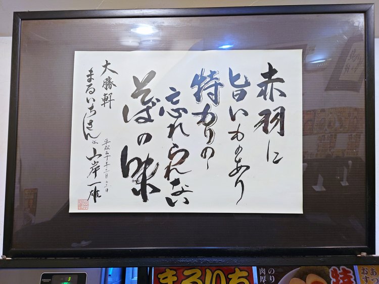 山岸一雄氏の書「赤羽に旨いものあり特もりのわすれられないそばの味」。