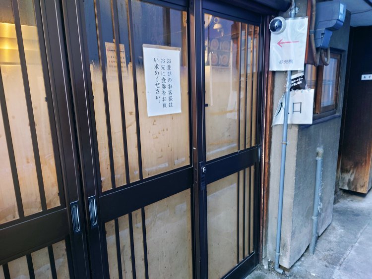 鰻の寝床のような長い造りで、狭い通路を奥に進むと入り口、入ると券売機がある。