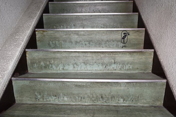 この細く狭い階段の先にカフェがあるとはちょっと想像しにくいが、途中のマークが上階へと誘う。