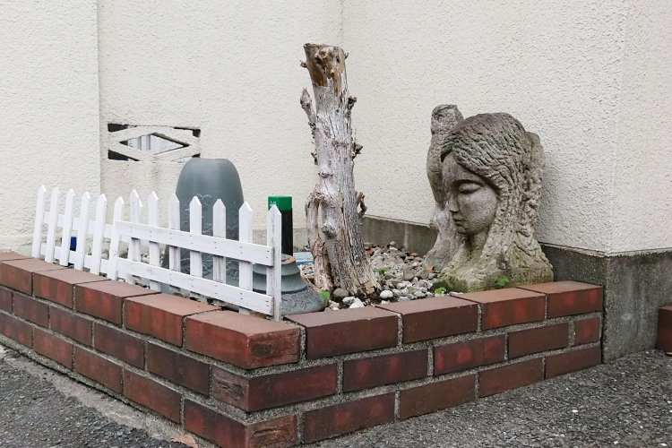 切られた木を見守る、どっしりとした存在感の置物。