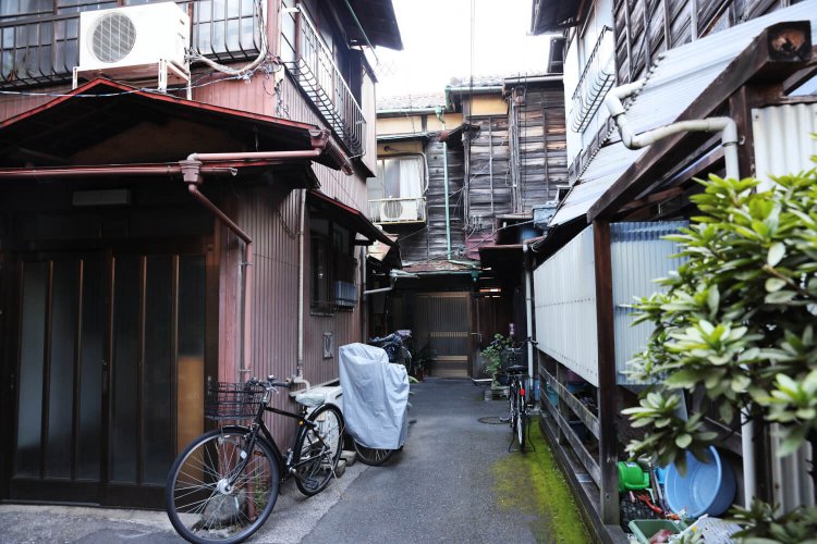 風情ある通路の奥の、さらに奥に静かに立つ古い木造家屋。守るべき貴重な「ドンツキ遺産」だ。通路の形状は、先折れ型。