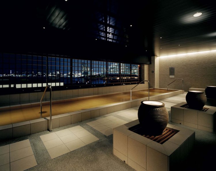 格子窓のむこうに横浜港の風景が広がる半露天風呂。温泉の泉源は海底にあるという。