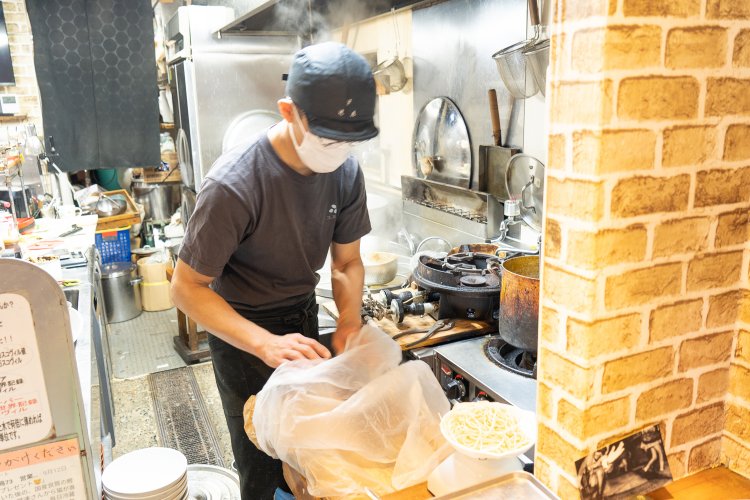 自家製麺を測る店主、浅羽範彦さん。スープやタレも計量して、味のブレを出さないのもポリシー。