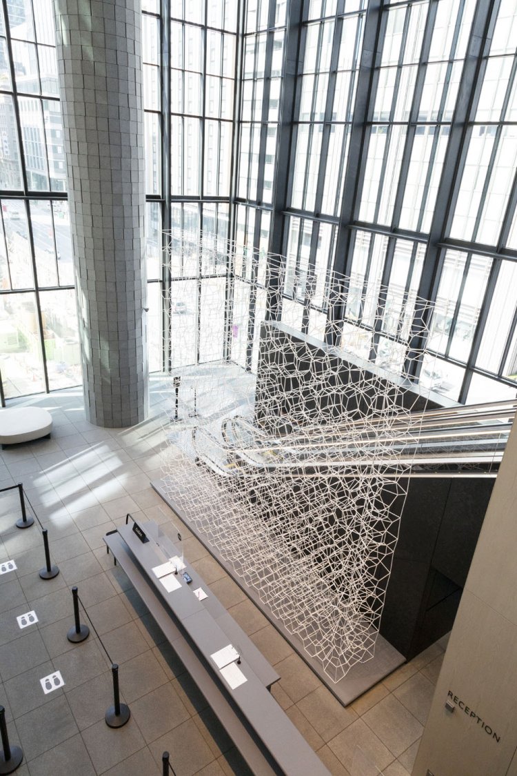 エスカレーターと受付をゆるやかに分けるオブジェが美しい。