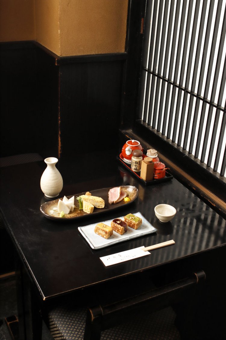 手前はそば味噌、ゆず味噌、木の芽味噌3種のそば麩田楽980円。おつまみ定番三点盛り1300円は板わさ、玉子焼き、鴨のロース煮。合わせる日本酒は菊正宗の常温780円。