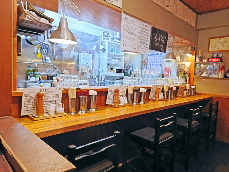 カウンター席の後ろに2～3名のテーブル席と、ラーメン店には珍しいワインセラーが。ラーメンにも合うワインが並ぶ。