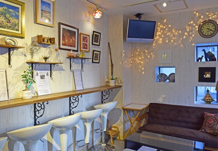 壁に飾られた写真はカメラマンである従妹の旦那さんの作品。子連れのお客さんのために、カウンター下に小さな子供用の椅子が置かれていた。母である店主の心遣い。