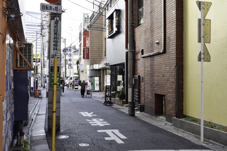 路地入り口からもわかる『炭火焙煎珈琲　利休』の立て看板。店名の由来はもちろん千利休からだが、“利用して休んでほしい”という想いも込められている。
