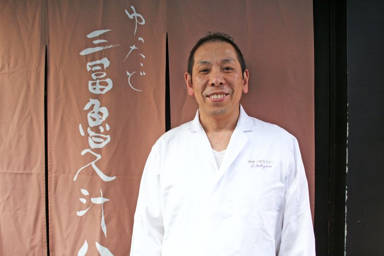 店主の石沢勉さん。味わいのある筆跡で書かれた店名は、石沢さんが左手で書いたものだそう。