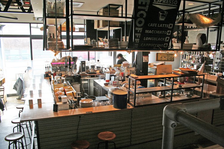 店の中央がキッチン。キッチンを囲むカウンター席のほか、テーブル席、ソファ席もある。