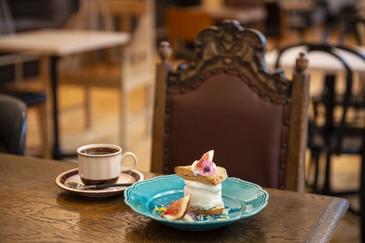 自家製アイスと旬のフルーツがマッチするもちきび入りビスケット900円（トッピングは季節によって異なります）と、美術館ブレンド600円。アンティークと新しい家具をミックスさせた店内も魅力。