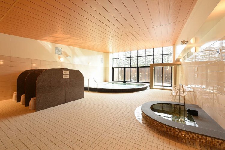 大浴場の浴室は1週間ごとに男女入れ替え制。窓の向こう側に人工炭酸泉の露天風呂がある。