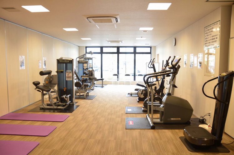 運動器具を備えたトレーニングルーム。セルフで血圧や体組成測定が行える健康管理システムが設置されている。