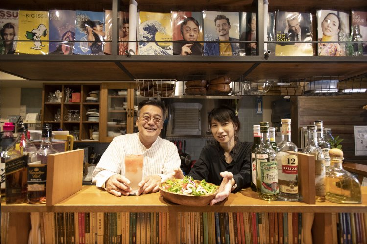 根井さんと料理担当の奥様。カウンターの文庫は著者の生年月日順に並ぶ。