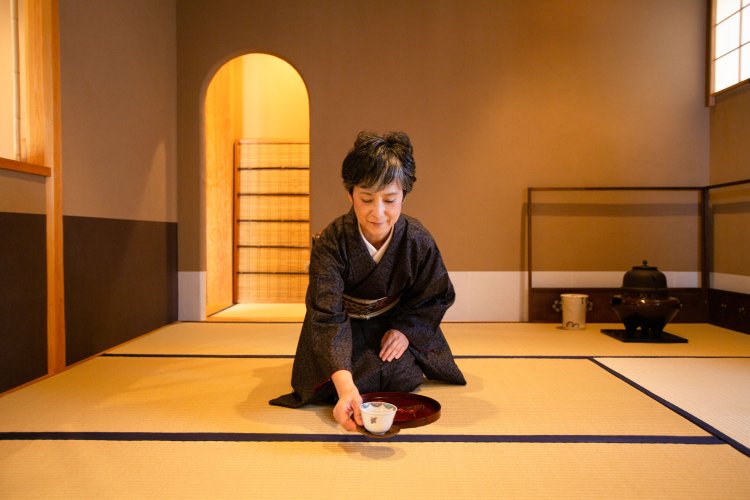 着物姿の塚田さん。畳の上に座れるほか、土間のテーブル席もある。