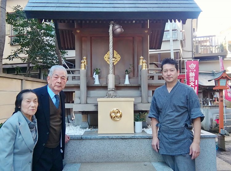 気象神社の賽銭箱を囲む初代夫婦と近藤さん。