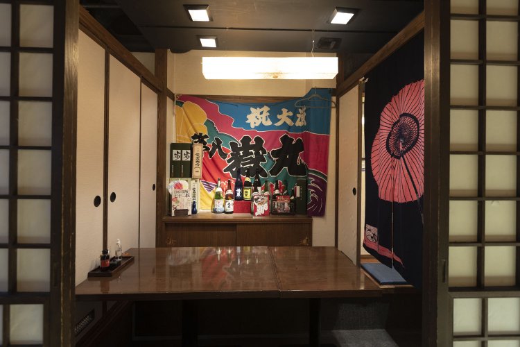 店は全席個室。飾られている大漁旗は、仕入れ元の漁船のもの。