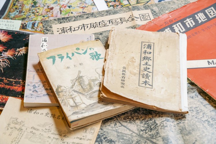 地図作成に使う資料。旧浦和市の地図や航空写真、浦和に住んだ水上勉の『フライパンの歌』も。
