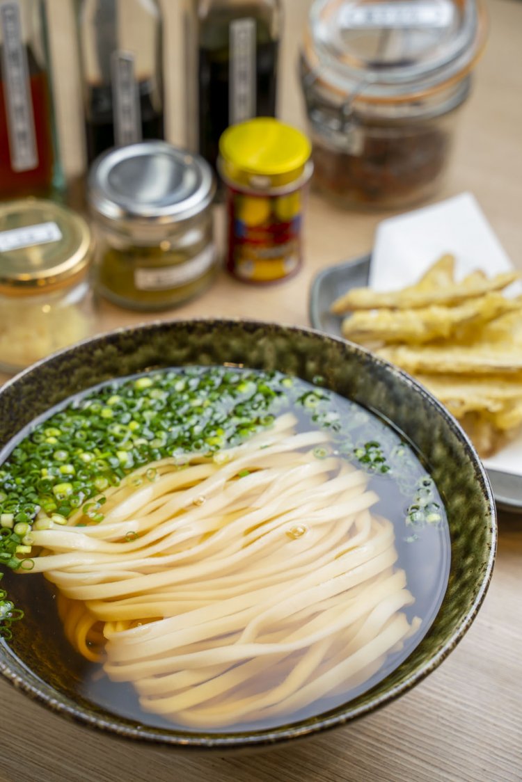 福岡 博多うどん。基本はやわふわで角のない麺や平麺が主流。出汁は、いりこやあごなどを用い、カエシには福岡の甘い醤油を使うので、ほんのり甘く澄んだつゆが特徴だ。