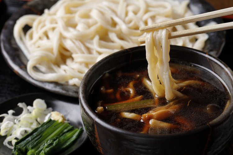 きのこつけ汁うどん750円。一度炒めたシイタケやブナシメジが汁にコクと香りを加える。おなかがすいているときは、ちくわ天130円や野菜天ぷら5品250円の追加もおすすめ。