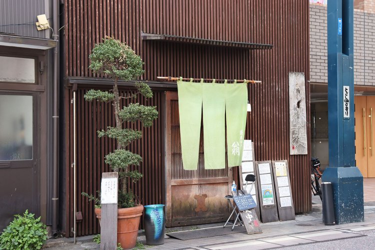 長年雨風に耐えた看板や引き戸に、お店の歴史を感じる。