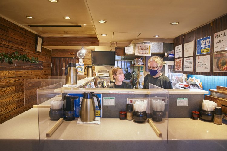 「油かすはうどん以外に使ってもうまい」と店主夫婦。油かすカレー950円、油かすオムライス950円なども品書きに並ぶ。