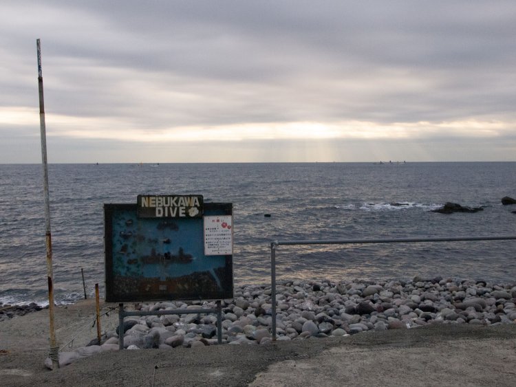 ダイビング当日は真冬の曇天であった。この看板は海中の状況で、ルートと遺構が立体図で記されていた。