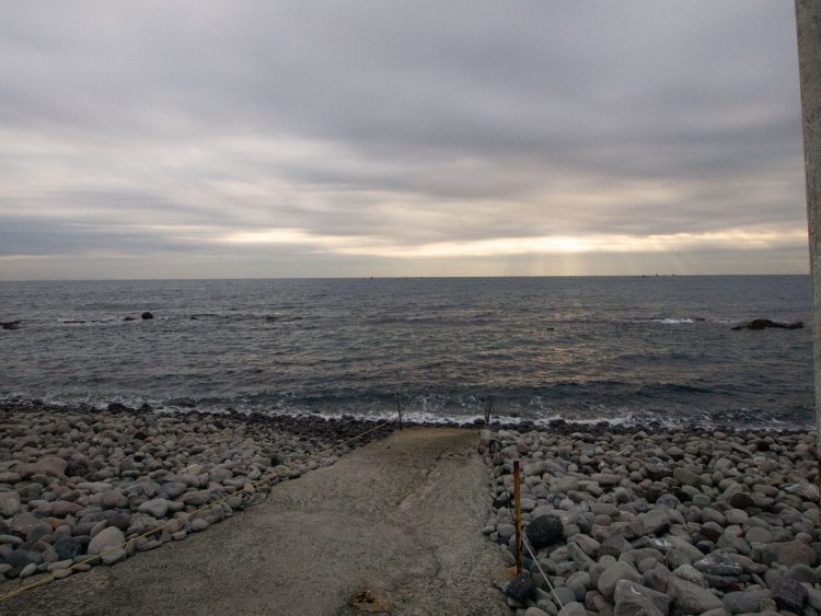 コンクリートの路面をボンベ背負って歩き、打ち寄せる波の中へ消えていくのである。