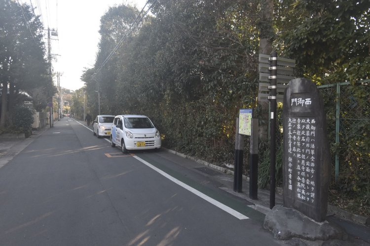 横浜国大付属小中学校の東側フェンス前に立つ西御門跡地を示す石碑。